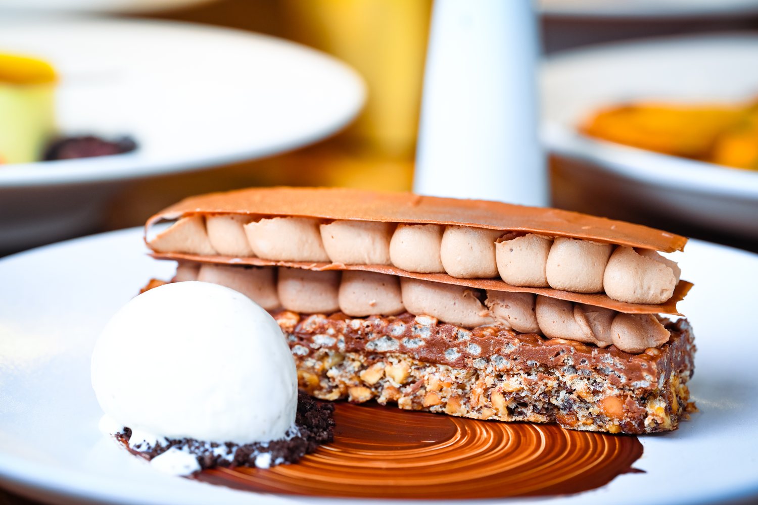 Layered chocolate dessert with ice cream at a restaurant table
