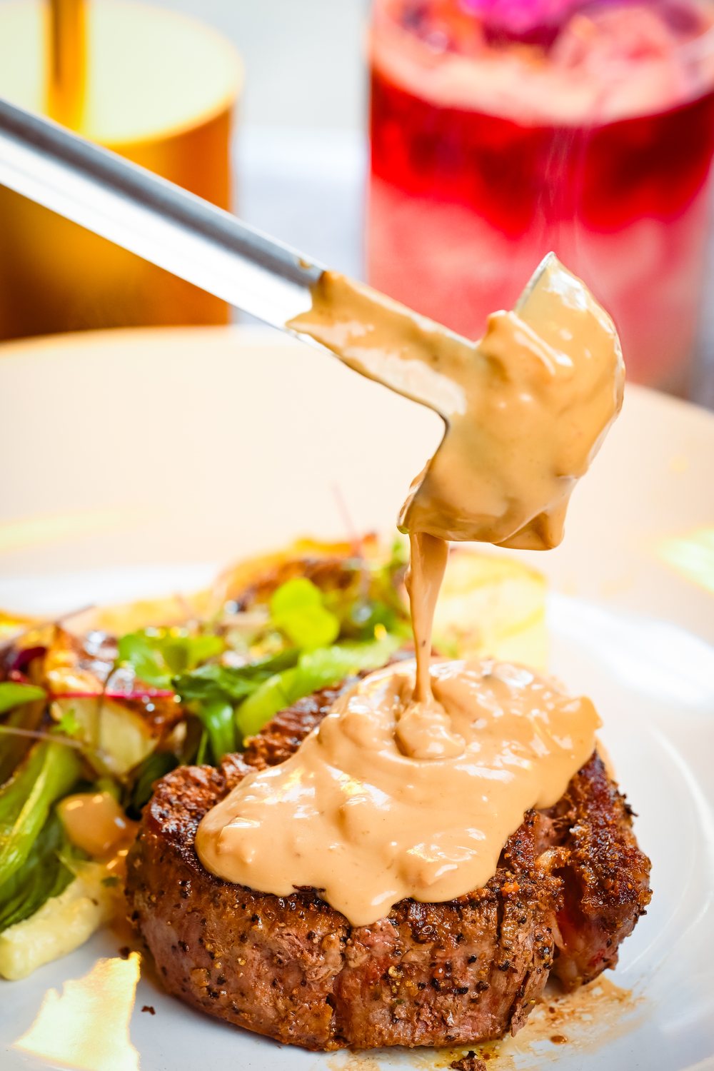 Sauce lifted above a plated entrée