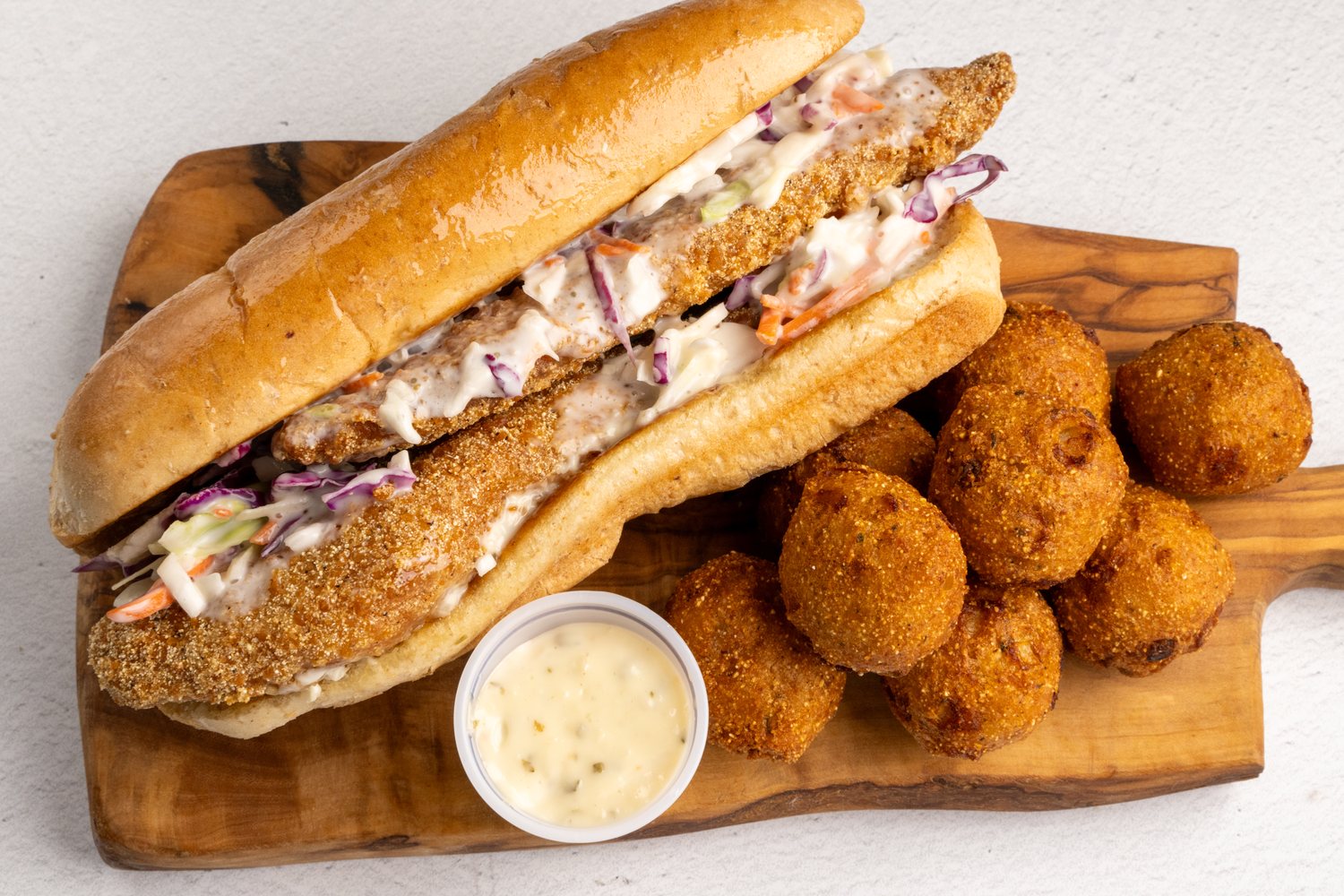 Fish sandwich with fried sides and dipping sauce