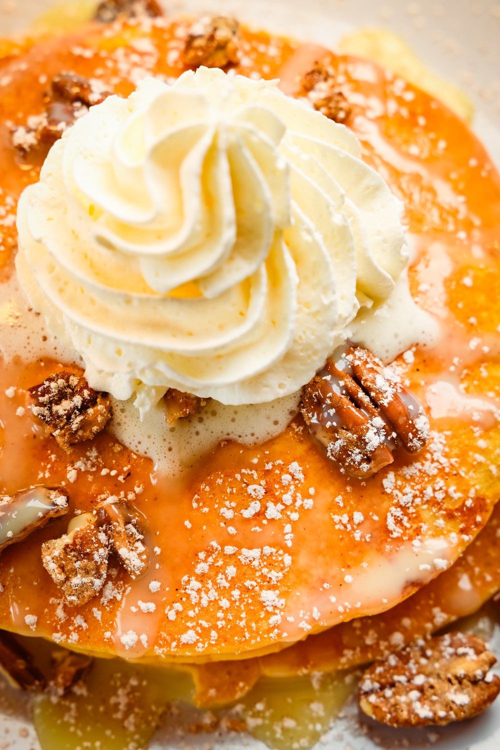 Finished pancake plate with cream and pecans, viewed from above