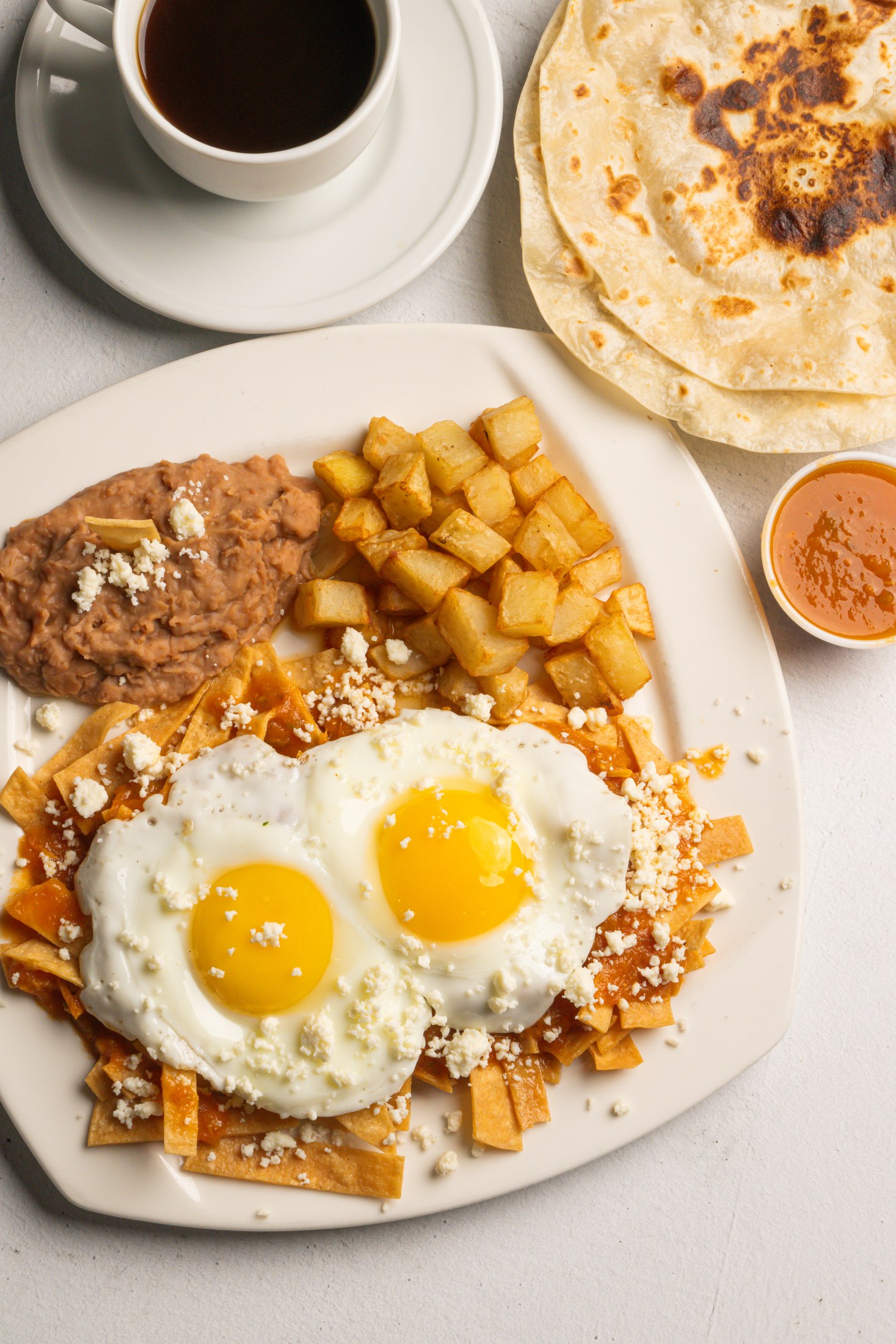 Chilaquiles with two eggs, beans, potatoes, and tortillas