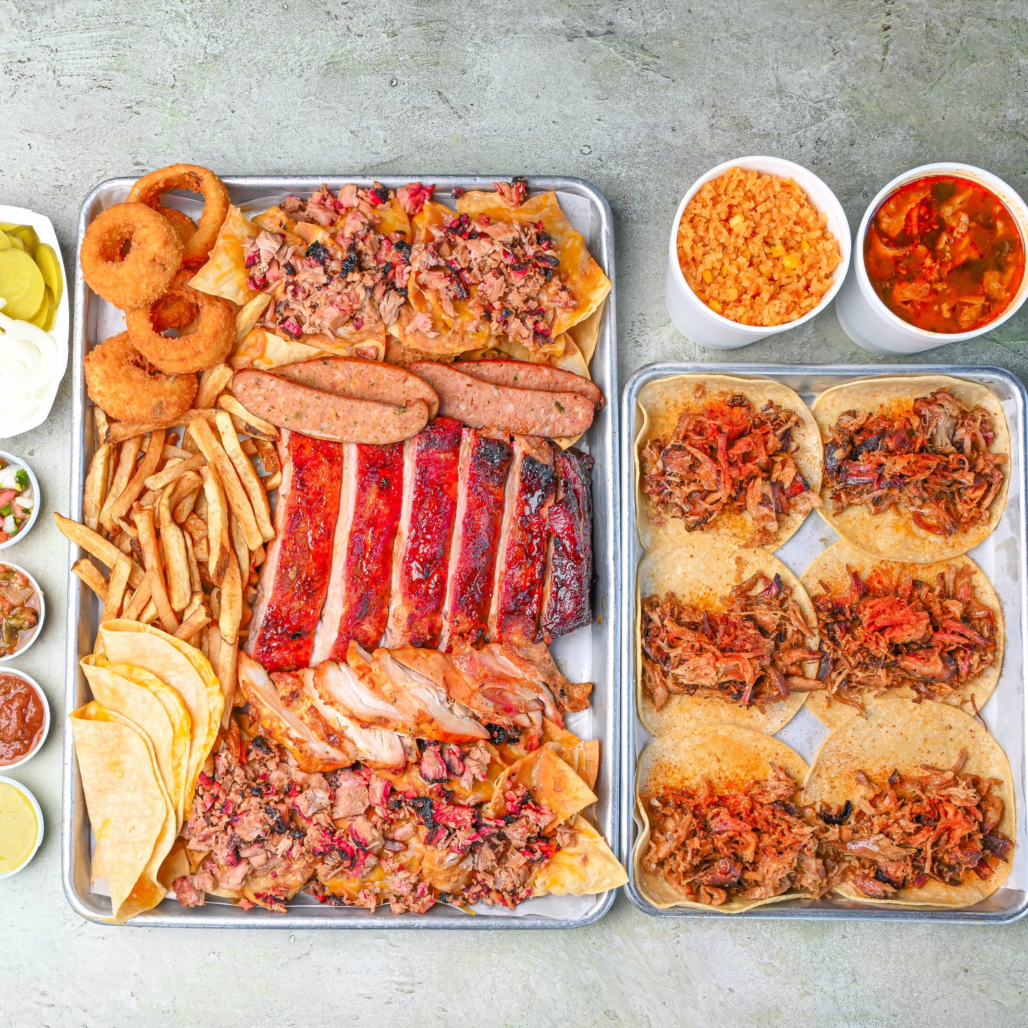 BBQ share platter with smoked meats, fries, onion rings, and tacos
